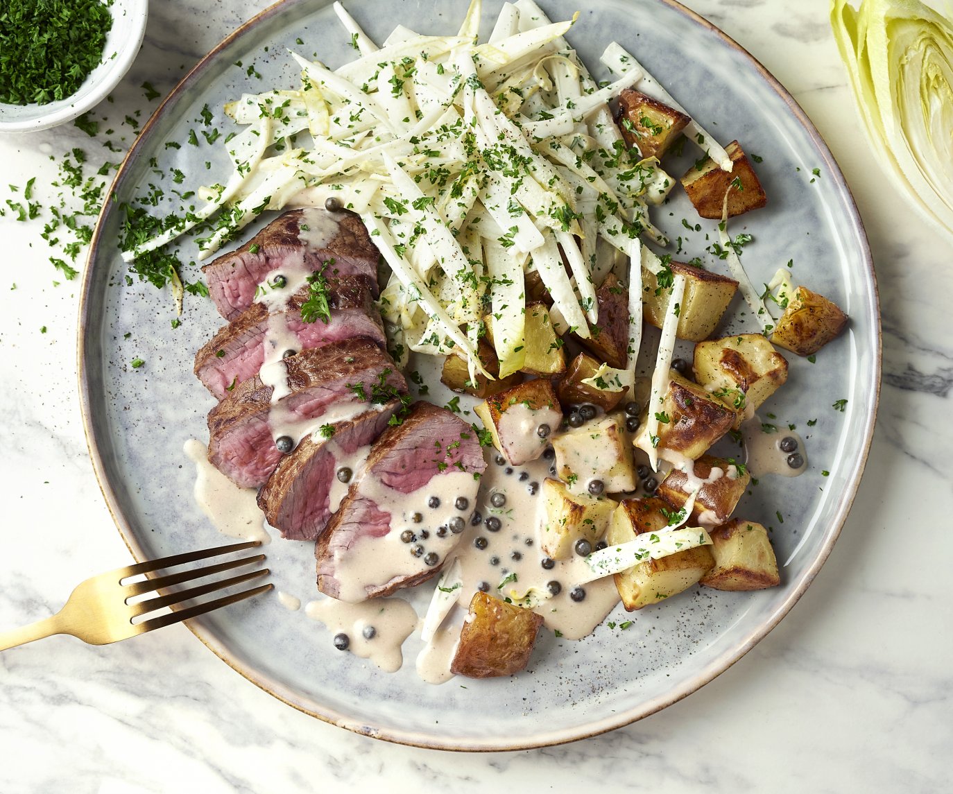 Steak met peperroomsaus, witloofsalade en geroosterde aardappelen